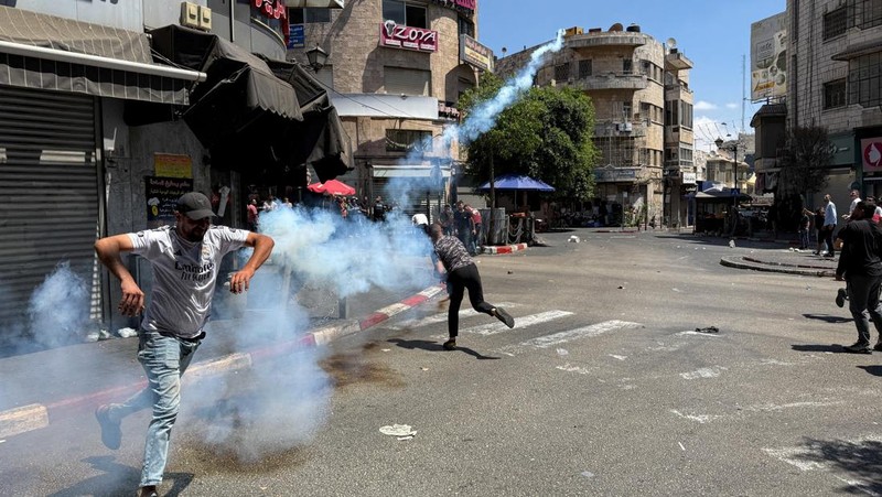 Warga Palestina melempar benda-benda, saat bentrok dengan pasukan Israel, selama serangan Israel di Ramallah, di Tepi Barat yang diduduki Israel, 26 Agustus 2025. (REUTERS/Mohammed Torokman)