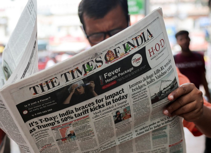 USA-TRUMP/TARIFFS-INDIA A man reads the latest edition of The Times of India newspaper, with the lead story on U.S. tariffs on most Indian goods, in the old quarters of Delhi, India, August 27, 2025. REUTERS/Anushree Fadnavis