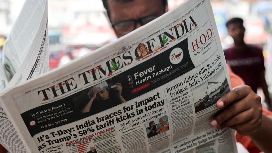 USA-TRUMP/TARIFFS-INDIA A man reads the latest edition of The Times of India newspaper, with the lead story on U.S. tariffs on most Indian goods, in the old quarters of Delhi, India, August 27, 2025. REUTERS/Anushree Fadnavis