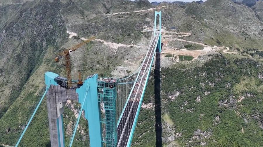 Jembatan Huajiang Grand Canyon di Provinsi Guizhou, Tiongkok barat daya, yang ditetapkan sebagai jembatan tertinggi di dunia, menyelesaikan uji beban utama pada hari Senin, menjelang pembukaan yang dijadwalkan pada akhir September. (Tangkapan Layar China Central Television via Reuters)