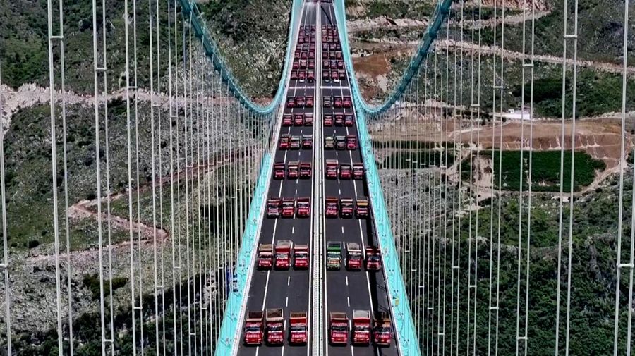 Jembatan Huajiang Grand Canyon di Provinsi Guizhou, Tiongkok barat daya, yang ditetapkan sebagai jembatan tertinggi di dunia, menyelesaikan uji beban utama pada hari Senin, menjelang pembukaan yang dijadwalkan pada akhir September. (Tangkapan Layar China Central Television via Reuters)