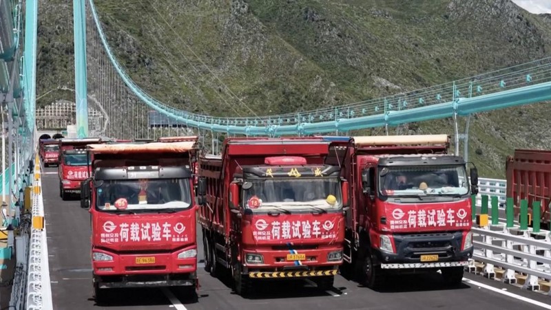 Jembatan Huajiang Grand Canyon di Provinsi Guizhou, Tiongkok barat daya, yang ditetapkan sebagai jembatan tertinggi di dunia, menyelesaikan uji beban utama pada hari Senin, menjelang pembukaan yang dijadwalkan pada akhir September. (Tangkapan Layar China Central Television via Reuters)