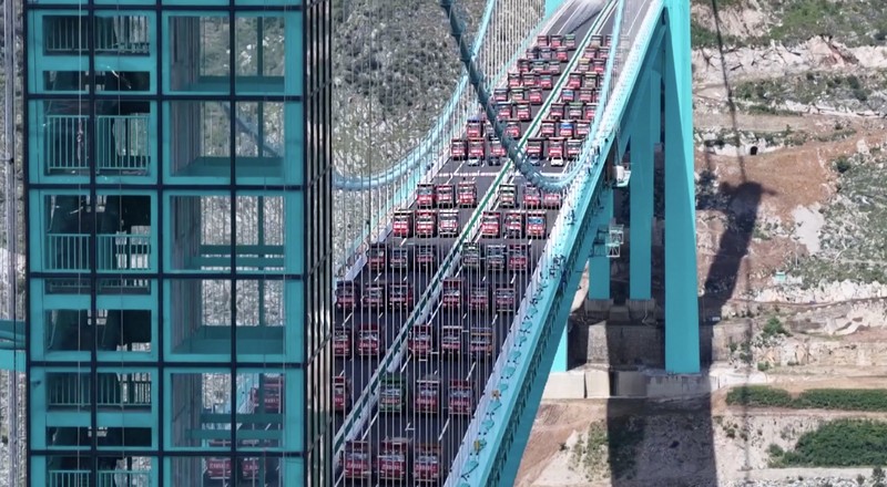 Jembatan Huajiang Grand Canyon di Provinsi Guizhou Jembatan Huajiang Grand Canyon di Provinsi Guizhou, Tiongkok barat daya, yang ditetapkan sebagai jembatan tertinggi di dunia, menyelesaikan uji beban utama pada hari Senin, menjelang pembukaan yang dijadwalkan pada akhir September. (Tangkapan Layar China Central Television via Reuters)