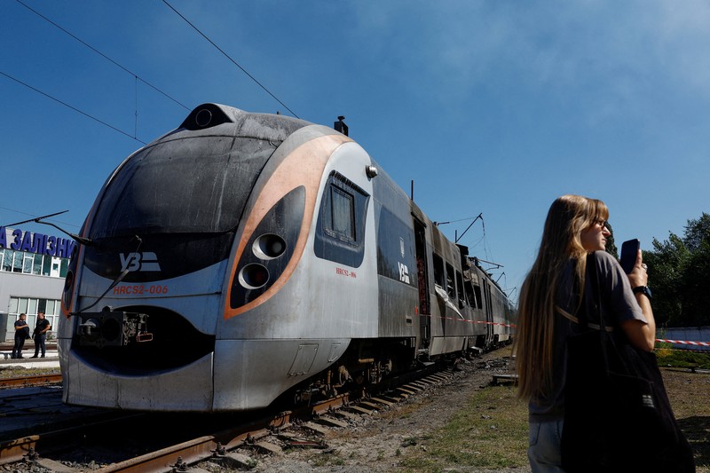 Pekerja berdiri di samping kereta HRCS2 Hyundai Rotem milik Kereta Api Ukraina yang terkena serangan pesawat tak berawak Rusia, di tengah serangan Rusia terhadap Ukraina, di Kyiv, Ukraina, 28 Agustus 2025. Pekerja berdiri di samping kereta HRCS2 Hyundai Rotem milik Kereta Api Ukraina yang terkena serangan pesawat tak berawak Rusia, di tengah serangan Rusia terhadap Ukraina, di Kyiv, Ukraina, 28 Agustus 2025. (REUTERS/Valentyn Ogirenko)