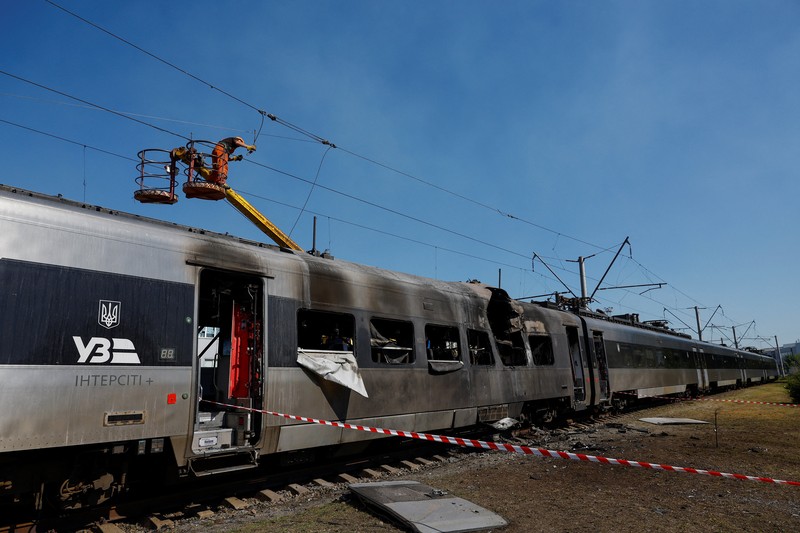 Pekerja berdiri di samping kereta HRCS2 Hyundai Rotem milik Kereta Api Ukraina yang terkena serangan pesawat tak berawak Rusia, di tengah serangan Rusia terhadap Ukraina, di Kyiv, Ukraina, 28 Agustus 2025. Pekerja berdiri di samping kereta HRCS2 Hyundai Rotem milik Kereta Api Ukraina yang terkena serangan pesawat tak berawak Rusia, di tengah serangan Rusia terhadap Ukraina, di Kyiv, Ukraina, 28 Agustus 2025. (REUTERS/Valentyn Ogirenko)