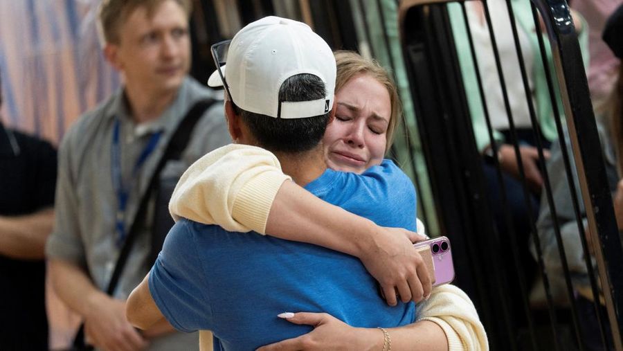 Families and loved ones reunite outside the police barricades after a shooting at Annunciation Church, which is also home to an elementary school, in Minneapolis, Minnesota, U.S. August 27, 2025.  REUTERS/Ben Brewer