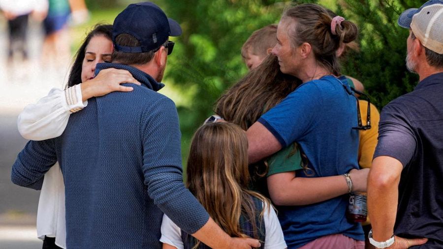 Families and loved ones reunite outside the police barricades after a shooting at Annunciation Church, which is also home to an elementary school, in Minneapolis, Minnesota, U.S. August 27, 2025.  REUTERS/Ben Brewer