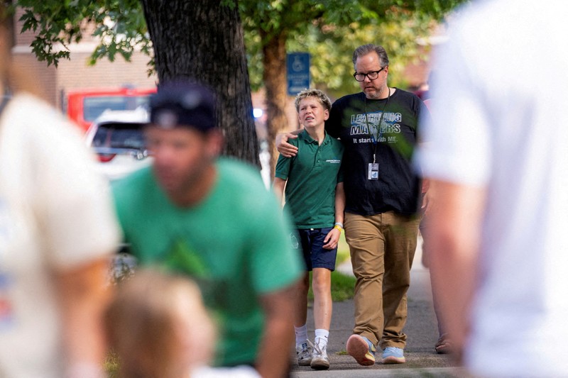 USA-MINNEAPOLIS/SHOOTING Families and loved ones reunite outside the police barricades after a shooting at Annunciation Church, which is also home to an elementary school, in Minneapolis, Minnesota, U.S. August 27, 2025. REUTERS/Ben Brewer