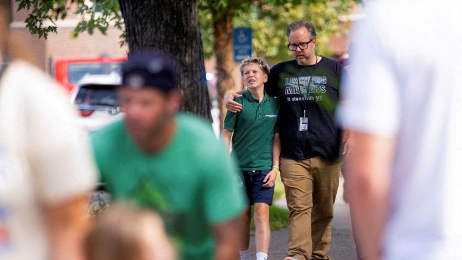 Families and loved ones reunite outside the police barricades after a shooting at Annunciation Church, which is also home to an elementary school, in Minneapolis, Minnesota, U.S. August 27, 2025.  REUTERS/Ben Brewer