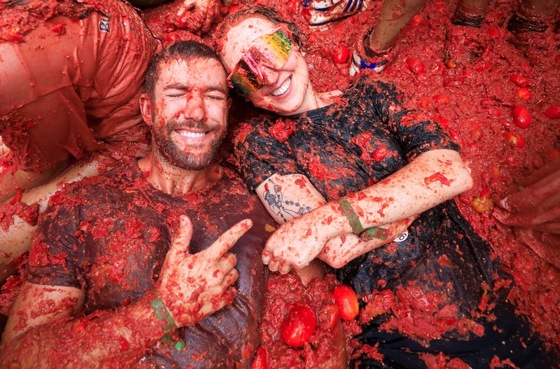 Para pengunjung yang bersuka ria bermain dengan bubur tomat selama festival perang makanan tahunan 'La Tomatina' di Bunol, dekat Valencia, Spanyol, 27 Agustus 2025. Para pengunjung yang bersuka ria bermain dengan bubur tomat selama festival perang makanan tahunan 'La Tomatina' di Bunol, dekat Valencia, Spanyol, 27 Agustus 2025. (REUTERS/Eva Manez)