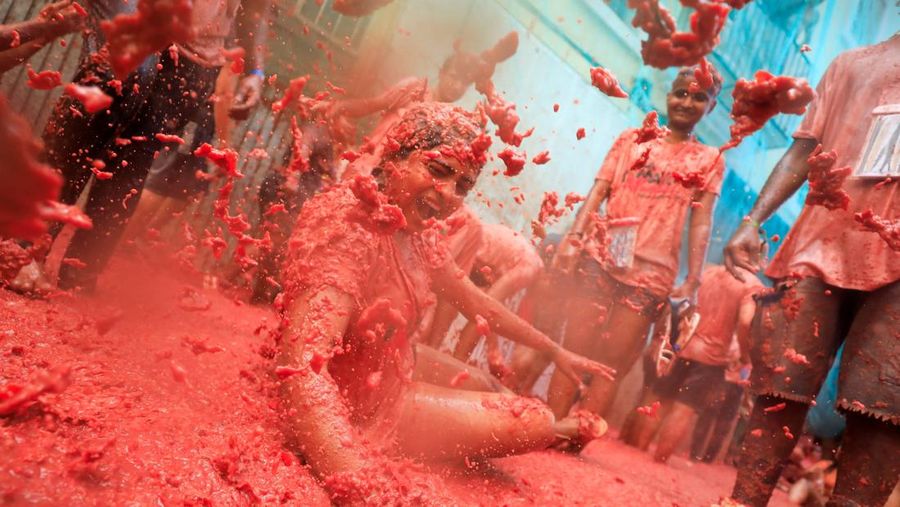 Para pengunjung yang bersuka ria bermain dengan bubur tomat selama festival perang makanan tahunan 'La Tomatina' di Bunol, dekat Valencia, Spanyol, 27 Agustus 2025. (REUTERS/Eva Manez)