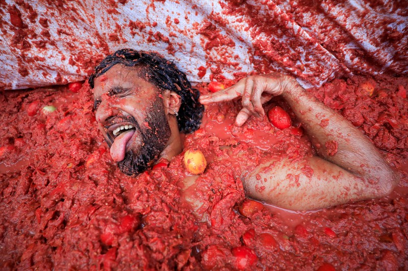 Para pengunjung yang bersuka ria bermain dengan bubur tomat selama festival perang makanan tahunan 'La Tomatina' di Bunol, dekat Valencia, Spanyol, 27 Agustus 2025. Para pengunjung yang bersuka ria bermain dengan bubur tomat selama festival perang makanan tahunan 'La Tomatina' di Bunol, dekat Valencia, Spanyol, 27 Agustus 2025. (REUTERS/Eva Manez)