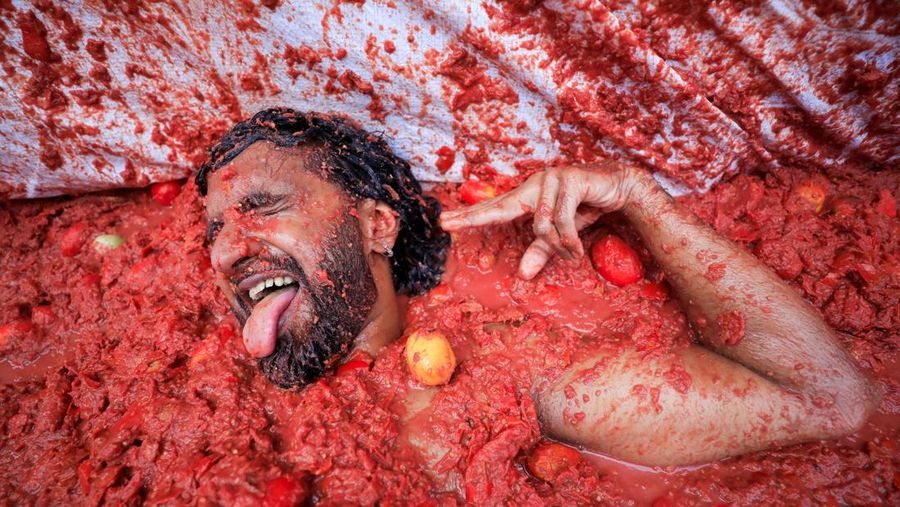Para pengunjung yang bersuka ria bermain dengan bubur tomat selama festival perang makanan tahunan 'La Tomatina' di Bunol, dekat Valencia, Spanyol, 27 Agustus 2025. Para pengunjung yang bersuka ria bermain dengan bubur tomat selama festival perang makanan tahunan 'La Tomatina' di Bunol, dekat Valencia, Spanyol, 27 Agustus 2025. (REUTERS/Eva Manez)