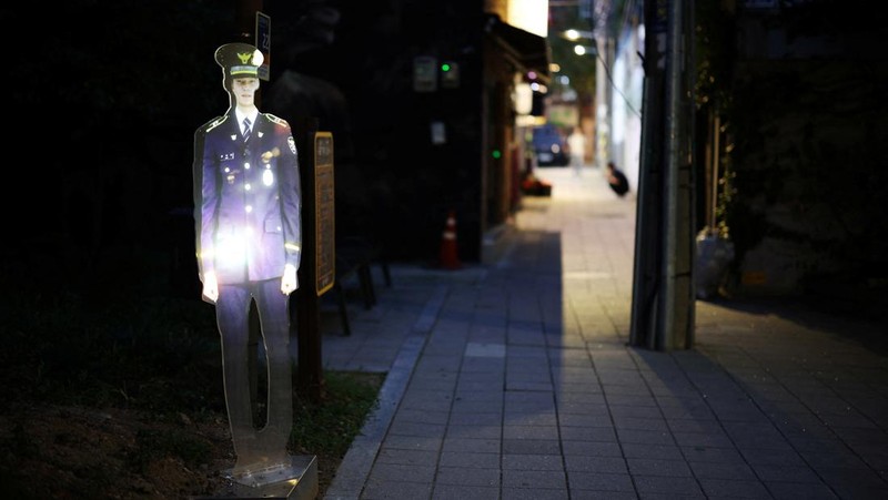 People walk near a life-size holographic police officer installed to prevent crime at a park in Seoul, South Korea, August 28, 2025. REUTERS/Kim Hong-Ji