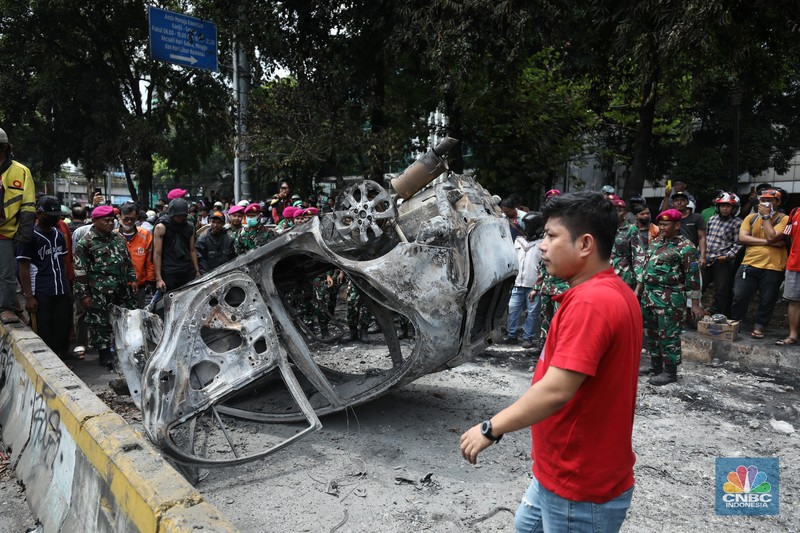 Warga mengambil sisa-sisa besi dari mobil yang hangus terbakar saat aksi di kawasan Mako Brimob Kwitang, Jakarta, Jumat (29/8/2025). (CNBC Indonesia/Tri Susilo) Warga mengambil sisa-sisa besi dari mobil yang hangus terbakar saat aksi di kawasan Mako Brimob Kwitang, Jakarta, Jumat (29/8/2025). (CNBC Indonesia/Tri Susilo)