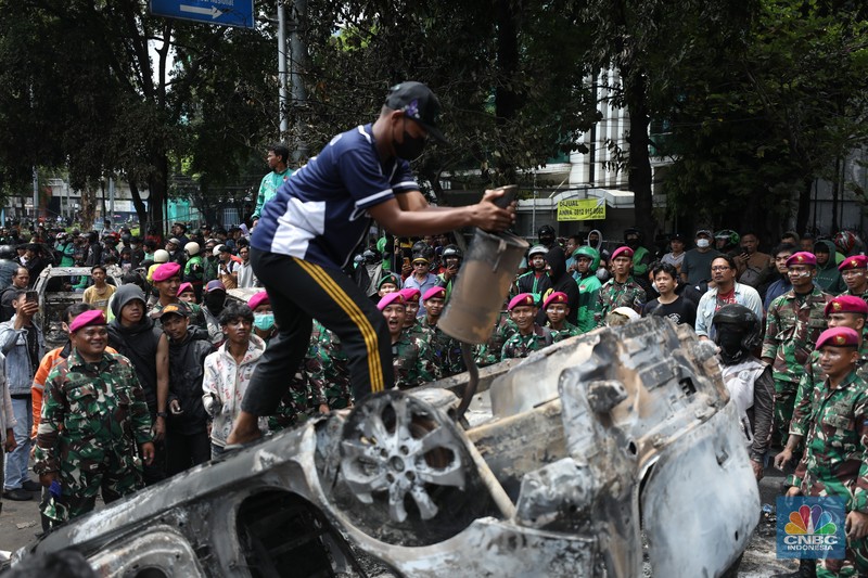 Warga mengambil sisa-sisa besi dari mobil yang hangus terbakar saat aksi di kawasan Mako Brimob Kwitang, Jakarta, Jumat (29/8/2025). (CNBC Indonesia/Tri Susilo) Warga mengambil sisa-sisa besi dari mobil yang hangus terbakar saat aksi di kawasan Mako Brimob Kwitang, Jakarta, Jumat (29/8/2025). (CNBC Indonesia/Tri Susilo)