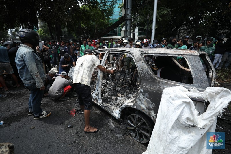 Warga mengambil sisa-sisa besi dari mobil yang hangus terbakar saat aksi di kawasan Mako Brimob Kwitang, Jakarta, Jumat (29/8/2025). (CNBC Indonesia/Tri Susilo) Warga mengambil sisa-sisa besi dari mobil yang hangus terbakar saat aksi di kawasan Mako Brimob Kwitang, Jakarta, Jumat (29/8/2025). (CNBC Indonesia/Tri Susilo)