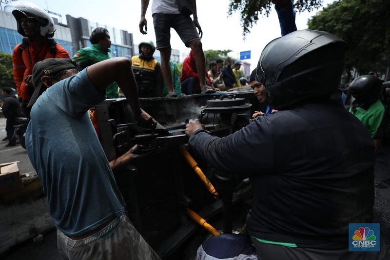 Warga mengambil sisa-sisa besi dari mobil yang hangus terbakar saat aksi di kawasan Mako Brimob Kwitang, Jakarta, Jumat (29/8/2025). (CNBC Indonesia/Tri Susilo) Warga mengambil sisa-sisa besi dari mobil yang hangus terbakar saat aksi di kawasan Mako Brimob Kwitang, Jakarta, Jumat (29/8/2025). (CNBC Indonesia/Tri Susilo)