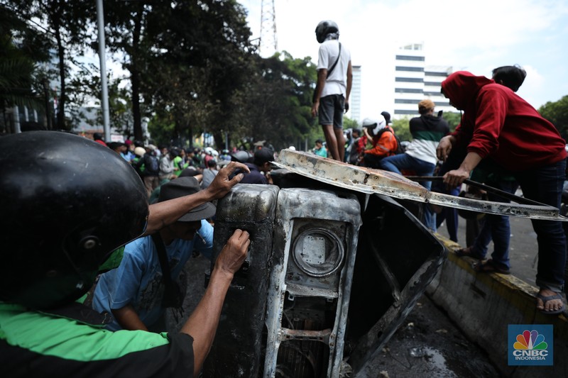 Warga mengambil sisa-sisa besi dari mobil yang hangus terbakar saat aksi di kawasan Mako Brimob Kwitang, Jakarta, Jumat (29/8/2025). (CNBC Indonesia/Tri Susilo) Warga mengambil sisa-sisa besi dari mobil yang hangus terbakar saat aksi di kawasan Mako Brimob Kwitang, Jakarta, Jumat (29/8/2025). (CNBC Indonesia/Tri Susilo)