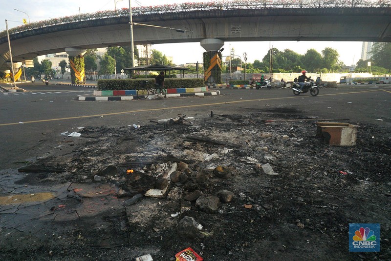 Warga melintas di depan markas Gegana atau pasukan elit dari Korps Brigade Mobil (Brimob) pada pagi hari usai menjadi target amukan demonstran di Jalan Kramat Raya, Senen, Jakarta Pusat, Sabtu, 30/8. (CNBC Indonesia/Muhamad Sabki)