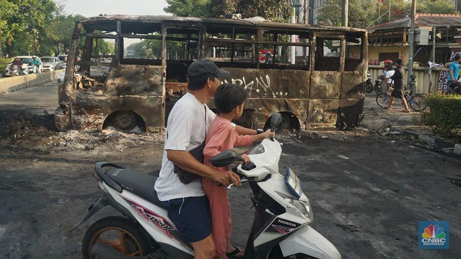 Warga melintas di depan markas Gegana atau pasukan elit dari Korps Brigade Mobil (Brimob) pada pagi hari usai menjadi target amukan demonstran di Jalan Kramat Raya, Senen, Jakarta Pusat, Sabtu, 30/8. (CNBC Indonesia/Muhamad Sabki)