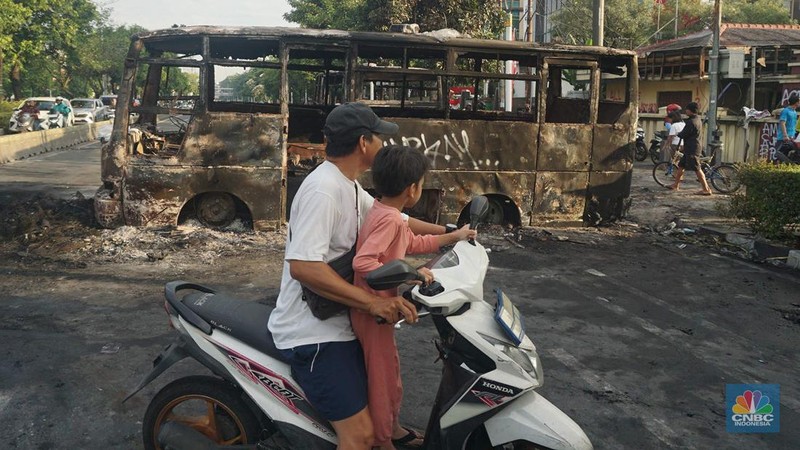 Warga melintas di depan markas Gegana atau pasukan elit dari Korps Brigade Mobil (Brimob) pada pagi hari usai menjadi target amukan demonstran di Jalan Kramat Raya, Senen, Jakarta Pusat, Sabtu, 30/8. (CNBC Indonesia/Muhamad Sabki)