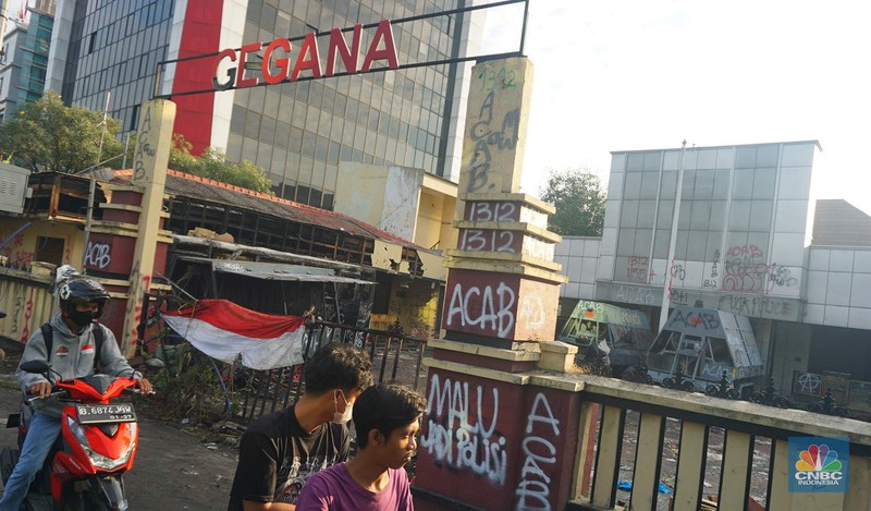 Warga melintas di depan markas Gegana atau pasukan elit dari Korps Brigade Mobil (Brimob) pada pagi hari usai menjadi target amukan demonstran di Jalan Kramat Raya, Senen, Jakarta Pusat, Sabtu, 30/8. (CNBC Indonesia/Muhamad Sabki)