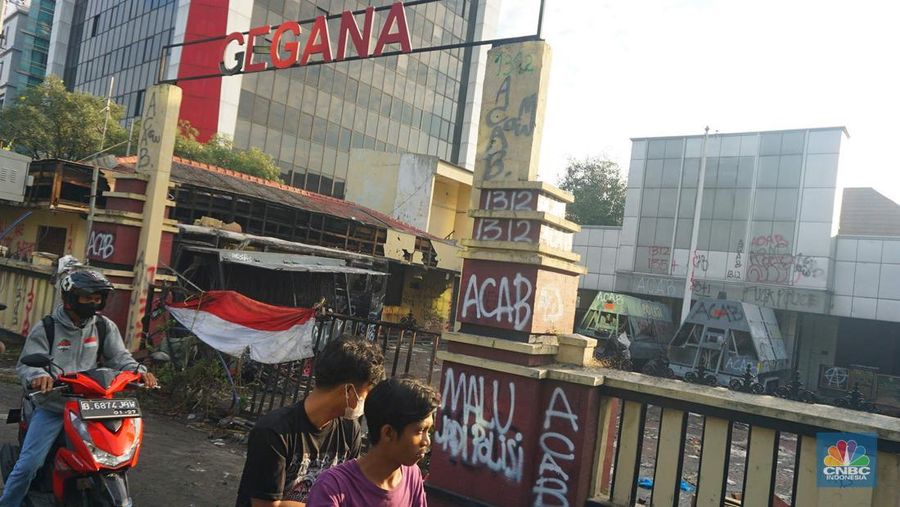 Warga melintas di depan markas Gegana atau pasukan elit dari Korps Brigade Mobil (Brimob) pada pagi hari usai menjadi target amukan demonstran di Jalan Kramat Raya, Senen, Jakarta Pusat, Sabtu, 30/8. (CNBC Indonesia/Muhamad Sabki)
