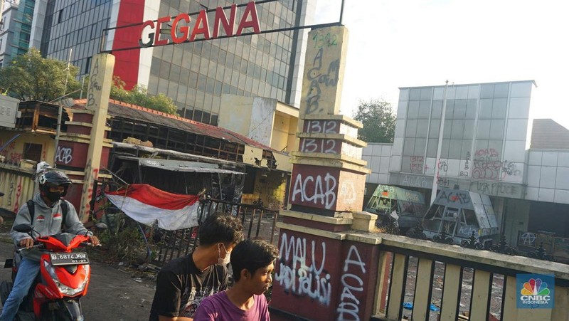 Warga melintas di depan markas Gegana atau pasukan elit dari Korps Brigade Mobil (Brimob) pada pagi hari usai menjadi target amukan demonstran di Jalan Kramat Raya, Senen, Jakarta Pusat, Sabtu, 30/8. (CNBC Indonesia/Muhamad Sabki)