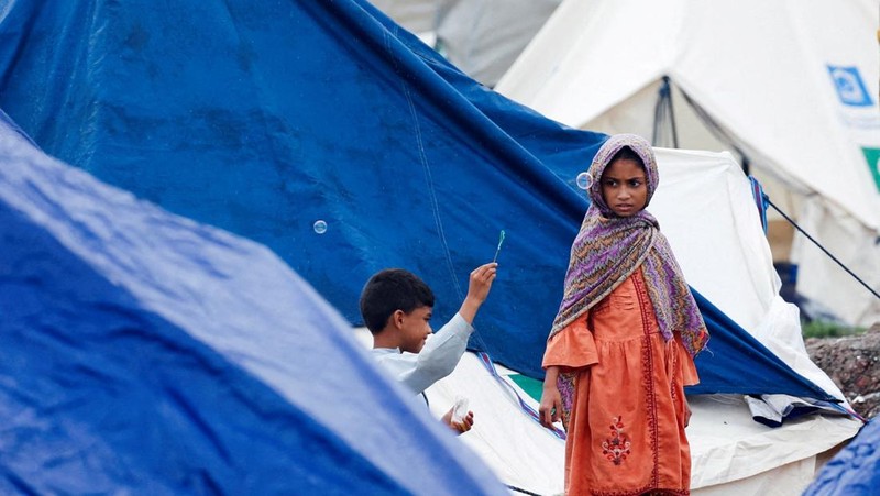 Seorang warga berjalan melewati daerah yang terendam banjir, menyusul hujan monsun dan naiknya permukaan air Sungai Sutlej, di desa Chanda Singh Wala dekat perbatasan Pakistan-India di distrik Kasur, provinsi Punjab, Pakistan, 29 Agustus 2025. (REUTERS/Akhtar Soomro)