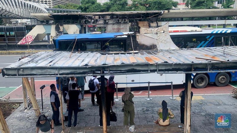 Sejumlah penumpang masih menggunakan halte TransJakarta Senayan Bank DKI, Jakarta, Senin (1/9/2025) usai terbakar pasca demonstrasi.  (CNBC Indonesia/Fergi Nadira)