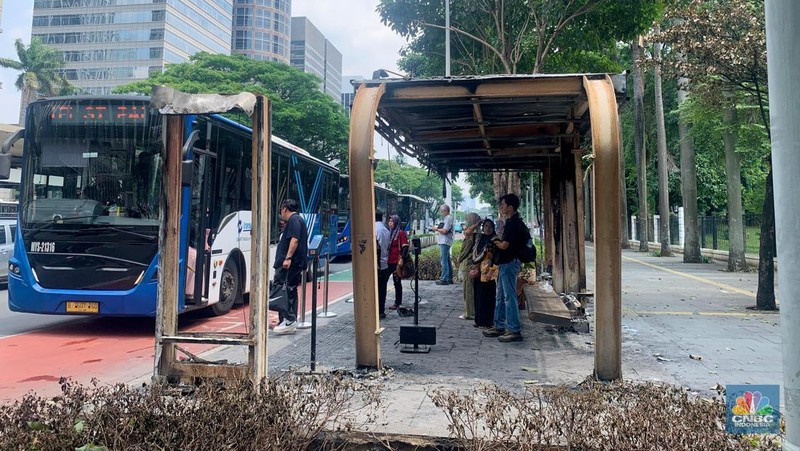 Sejumlah penumpang masih menggunakan halte TransJakarta Senayan Bank DKI, Jakarta, Senin (1/9/2025) usai terbakar pasca demonstrasi.  (CNBC Indonesia/Fergi Nadira)