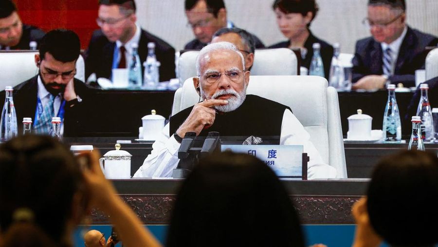 Wartawan mengambil gambar layar yang menyiarkan Perdana Menteri India Narendra Modi menghadiri sesi pleno KTT Organisasi Kerja Sama Shanghai (SCO) 2025 di Tianjin, Cina, 1 September 2025. (REUTERS/Maxim Shemetov)