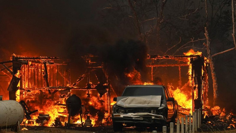 Api melalap sebuah rumah di Chinese Camp saat kebakaran hutan berkobar di Tuolumne County, California, AS, 2 September 2025. (REUTERS/Tracy Barbutes)