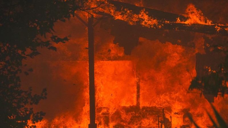 Api melalap sebuah rumah di Chinese Camp saat kebakaran hutan berkobar di Tuolumne County, California, AS, 2 September 2025. (REUTERS/Tracy Barbutes)