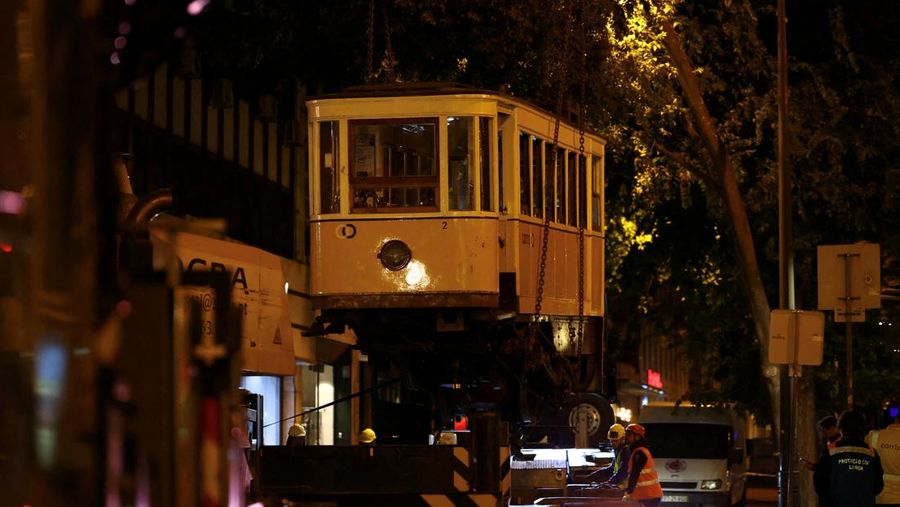 Para pekerja mengangkat puing-puing kereta gantung Ascensor da Glória di Lisbon, Portugal, Jumat (5/9/2025). (REUTERS/Pedro Nunes) Para pekerja mengangkat puing-puing kereta gantung Ascensor da Glória di Lisbon, Portugal, Jumat (5/9/2025). (REUTERS/Pedro Nunes)
