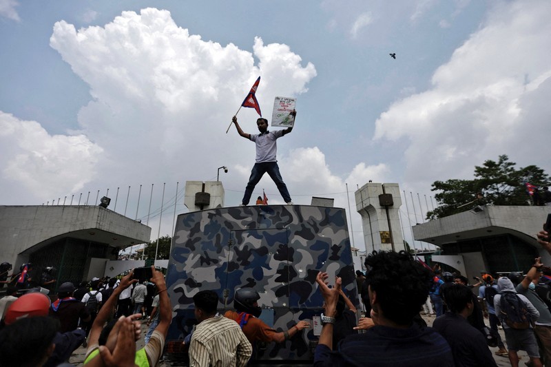 NEPAL-PROTESTS/ Smoke billows from an ambulance next to riot police officers and demonstrators during a protest against corruption and the government’s decision to block several social media platforms, in Kathmandu, Nepal September 8, 2025. REUTERS/Stringer