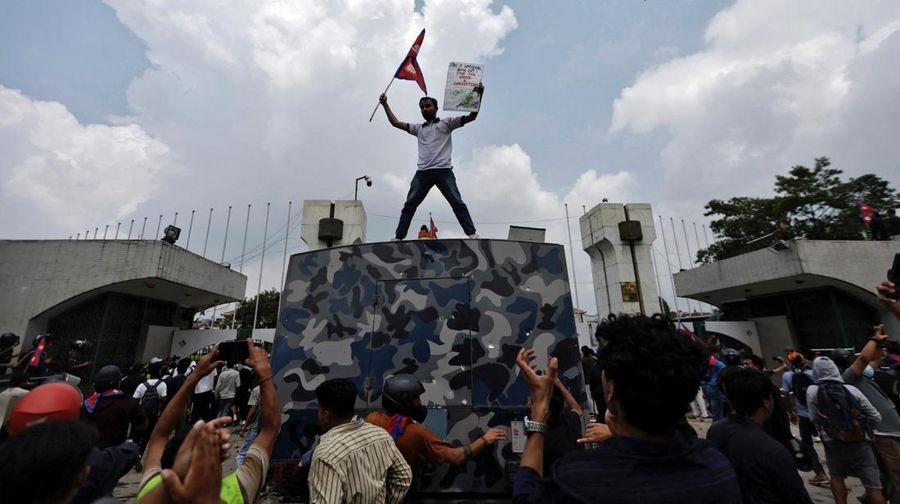 NEPAL-PROTESTS/ Smoke billows from an ambulance next to riot police officers and demonstrators during a protest against corruption and the government’s decision to block several social media platforms, in Kathmandu, Nepal September 8, 2025. REUTERS/Stringer