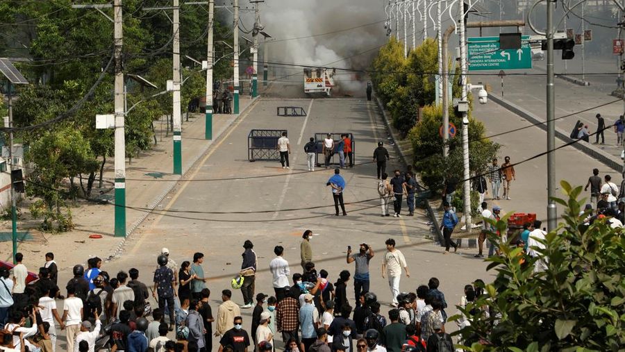 NEPAL-PROTESTS/ Smoke billows from an ambulance next to riot police officers and demonstrators during a protest against corruption and the government’s decision to block several social media platforms, in Kathmandu, Nepal September 8, 2025. REUTERS/Stringer