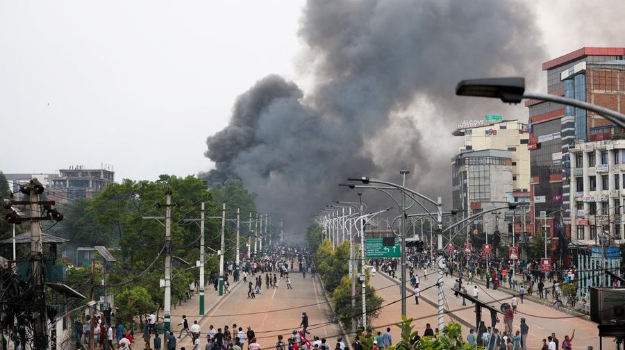 Para demonstran bereaksi di dekat asap yang mengepul dari kompleks Parlemen menyusul kebakaran yang terjadi selama protes terhadap tewasnya 19 orang pada hari Senin setelah protes antikorupsi yang dipicu oleh larangan media sosial, yang kemudian dicabut, selama jam malam di Kathmandu, Nepal, 9 September 2025. (REUTERS/Adnan Abidi)