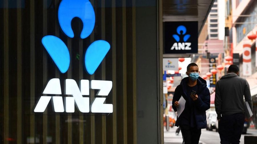 A man walks past an ANZ bank sign in Melbourne's Chinatown on April 30, 2020. Australia's ANZ Bank announced a 50-percent dive in after-tax profits, as the lender set aside one billion Australia dollars (655 million US) to cover expected losses resulting from the coronavirus fallout. (Photo by William WEST / AFP)