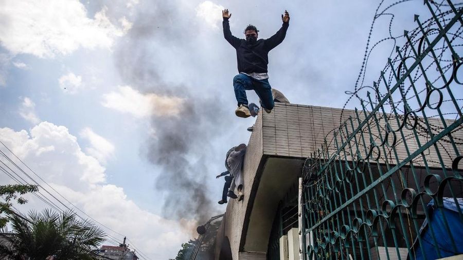 Demonstrators jump from the entrance wall of Nepal's Parliament building during a protest in Kathmandu on September 8, 2025, condemning social media prohibitions and corruption by the government. Nepal police on September 8 opened fire, killing at least 17 people as thousands of young protesters took to the streets of Kathmandu demanding the government lift a social media ban and tackle corruption. (Photo by PRABIN RANABHAT / AFP)