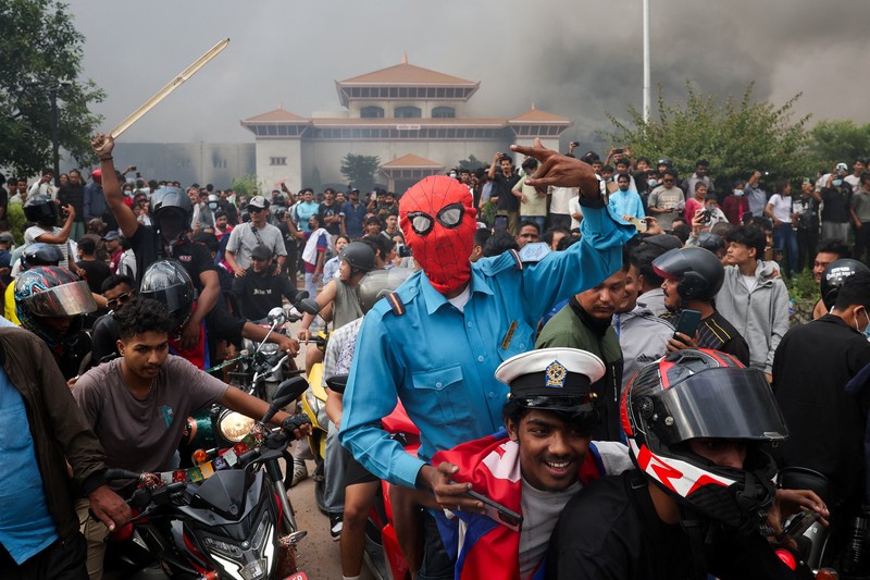 Para demonstran bereaksi di dekat asap yang mengepul dari kompleks Parlemen menyusul kebakaran yang terjadi selama protes terhadap tewasnya 19 orang pada hari Senin setelah protes antikorupsi yang dipicu oleh larangan media sosial, yang kemudian dicabut, selama jam malam di Kathmandu, Nepal, 9 September 2025. Para demonstran bereaksi di dekat asap yang mengepul dari kompleks Parlemen menyusul kebakaran yang terjadi selama protes terhadap tewasnya 19 orang pada hari Senin setelah protes antikorupsi yang dipicu oleh larangan media sosial, yang kemudian dicabut, selama jam malam di Kathmandu, Nepal, 9 September 2025. (REUTERS/Adnan Abidi)