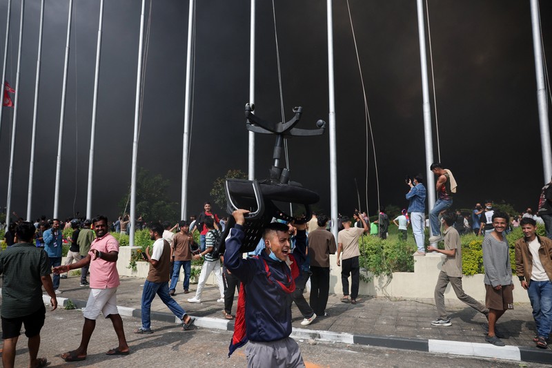 Para demonstran merayakan setelah memasuki kompleks Parlemen selama protes terhadap pembunuhan 19 orang pada hari Senin setelah protes antikorupsi yang dipicu oleh larangan media sosial, yang kemudian dicabut, selama jam malam di Kathmandu, Nepal, 9 September 2025. (REUTERS/Adnan Abidi)
