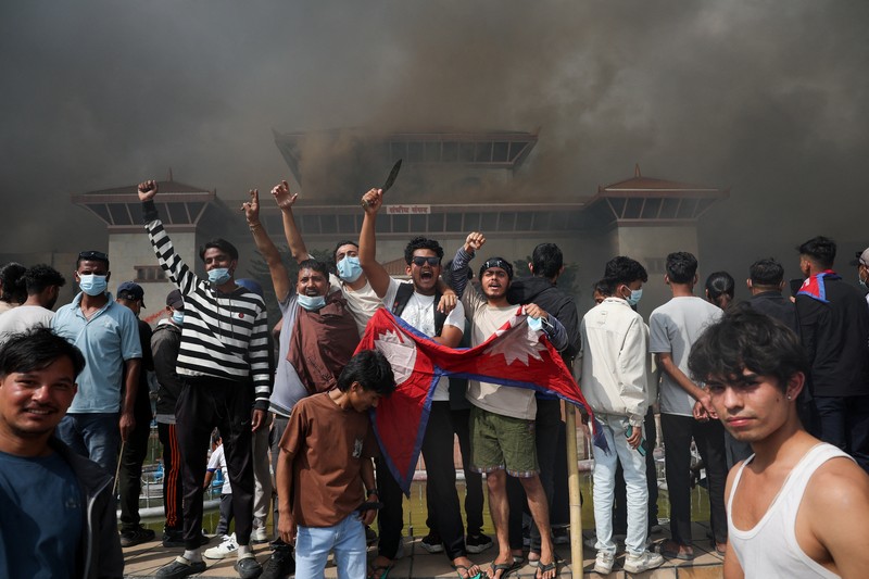 Para demonstran merayakan setelah memasuki kompleks Parlemen selama protes terhadap pembunuhan 19 orang pada hari Senin setelah protes antikorupsi yang dipicu oleh larangan media sosial, yang kemudian dicabut, selama jam malam di Kathmandu, Nepal, 9 September 2025. (REUTERS/Adnan Abidi)