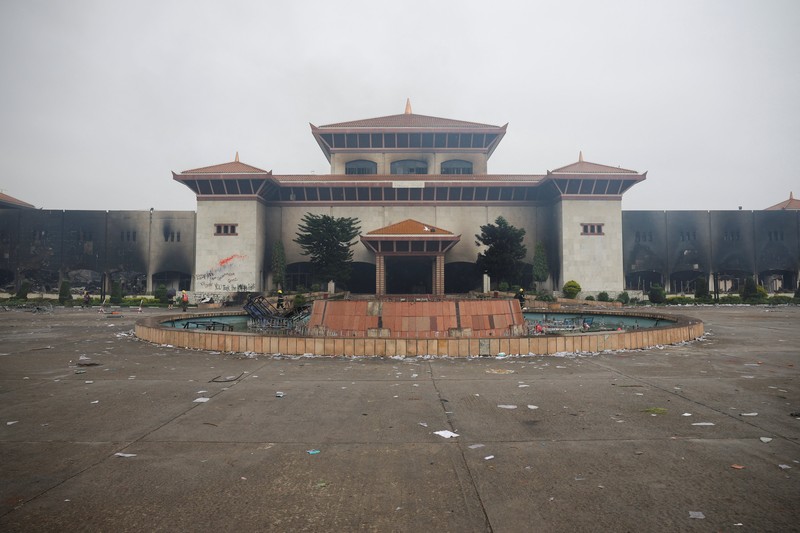 Seorang tentara Nepal berjaga-jaga saat tim tentara mencoba memadamkan api di gedung Parlemen, menyusul tewasnya 19 orang pada hari Senin setelah protes antikorupsi yang dipicu oleh larangan media sosial, yang kemudian dicabut, di Kathmandu, Nepal, 10 September 2025. (REUTERS/Adnan Abidi)