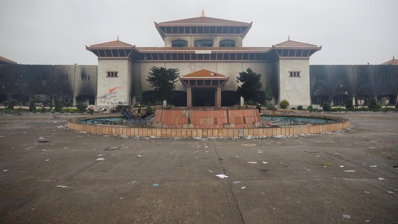 Seorang tentara Nepal berjaga-jaga saat tim tentara mencoba memadamkan api di gedung Parlemen, menyusul tewasnya 19 orang pada hari Senin setelah protes antikorupsi yang dipicu oleh larangan media sosial, yang kemudian dicabut, di Kathmandu, Nepal, 10 September 2025. (REUTERS/Adnan Abidi)