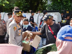 Aksi Polisi Bagikan Air Mineral dan Roti ke Massa Demo Buruh di Monas