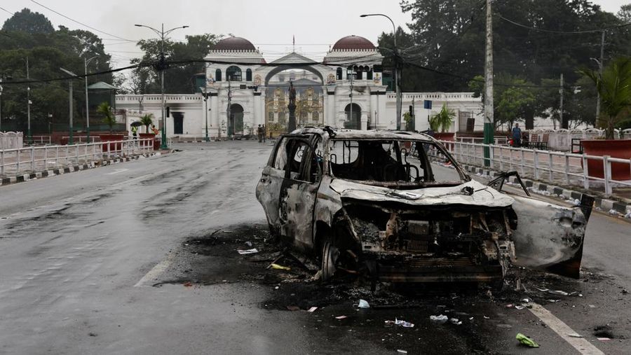 Seorang tentara Nepal berjaga-jaga saat tim tentara mencoba memadamkan api di gedung Parlemen, menyusul tewasnya 19 orang pada hari Senin setelah protes antikorupsi yang dipicu oleh larangan media sosial, yang kemudian dicabut, di Kathmandu, Nepal, 10 September 2025. (REUTERS/Adnan Abidi)
