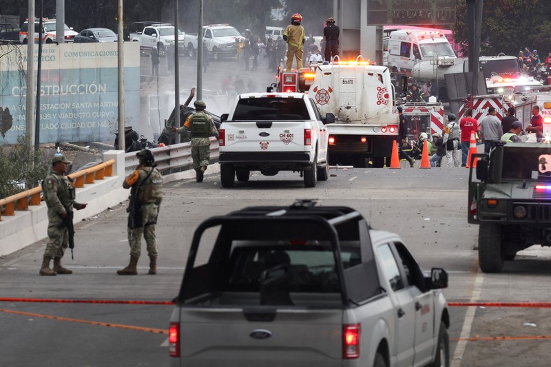 Seorang pria berjalan di samping sisa-sisa hangus sebuah trailer, salah satu kendaraan yang rusak dalam ledakan truk tangki gas di Jalan Ignacio Zaragoza, tempat beberapa orang mengalami luka bakar setelah truk tangki terbalik, di Mexico City, Meksiko, 10 September 2025. (REUTERS/Quetzalli Blanco)